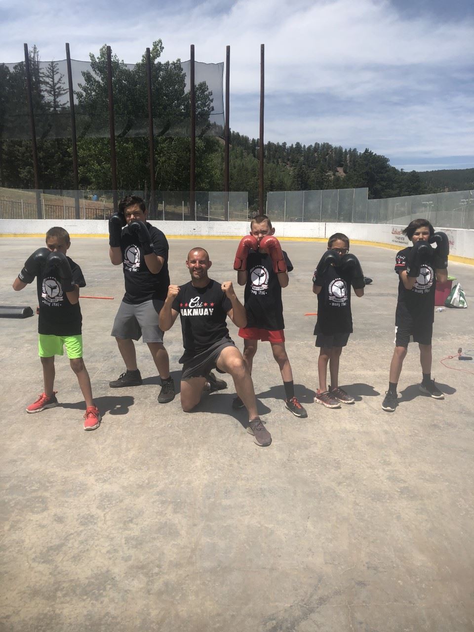 boxing students and instructors posing on hockey rink